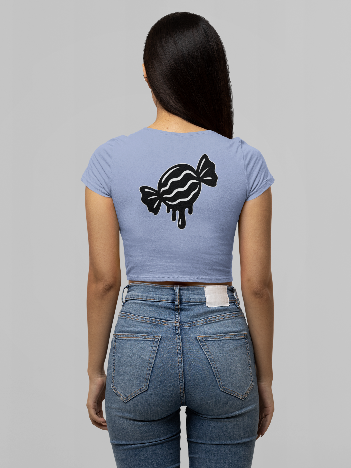 Person wearing a light blue t-shirt with a black candy design on the back, standing against a gray background.