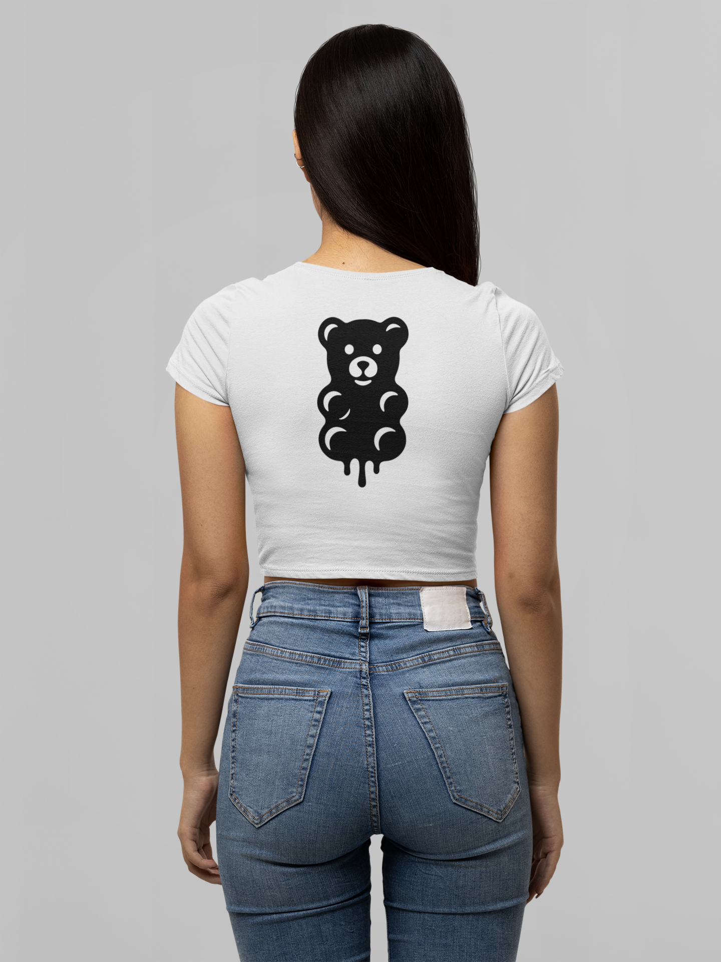 Person wearing a white t-shirt with a black bear graphic on the back, standing against a gray background.