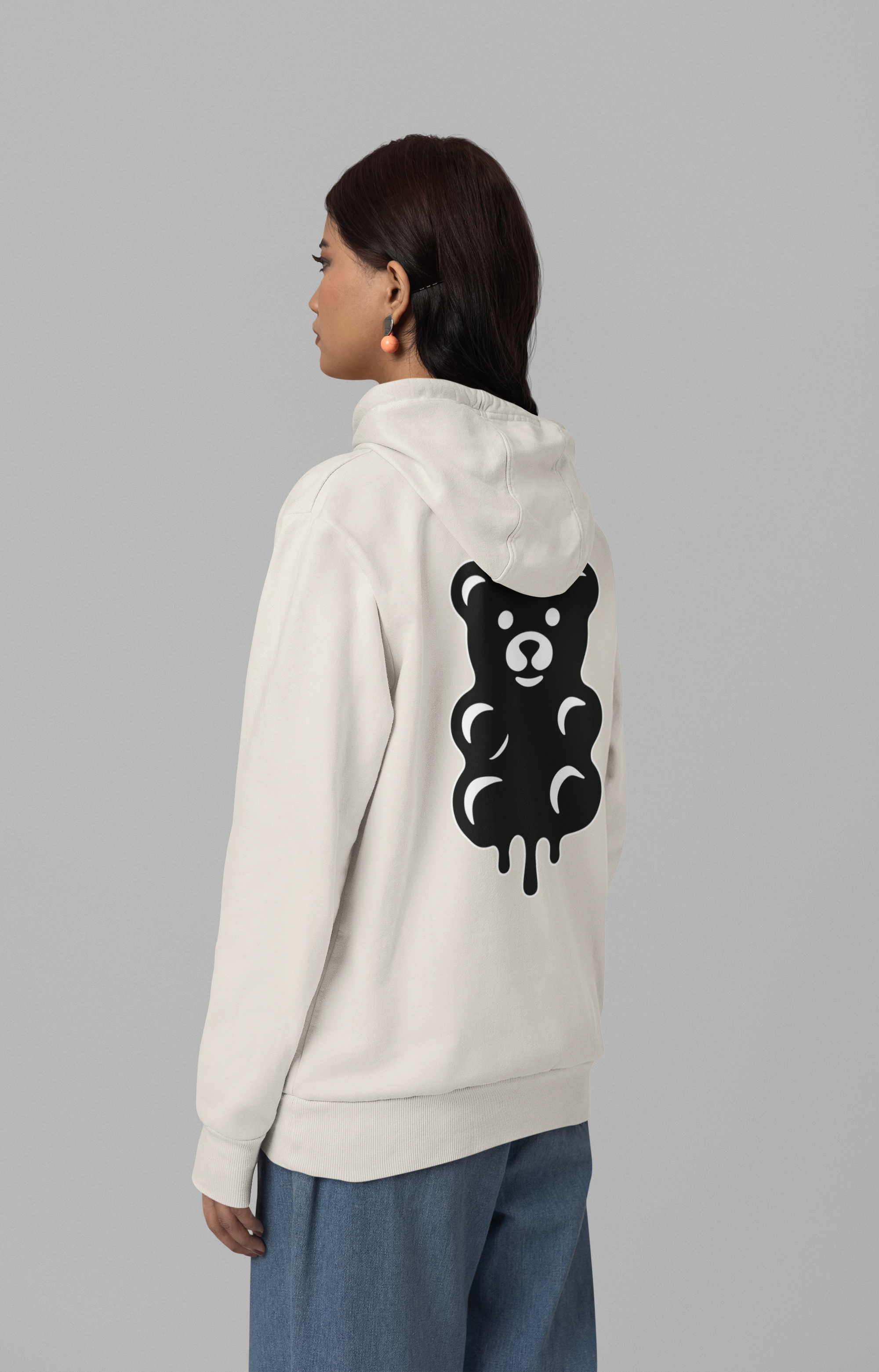 Person wearing a white hoodie with a black bear graphic on the back against a gray background
