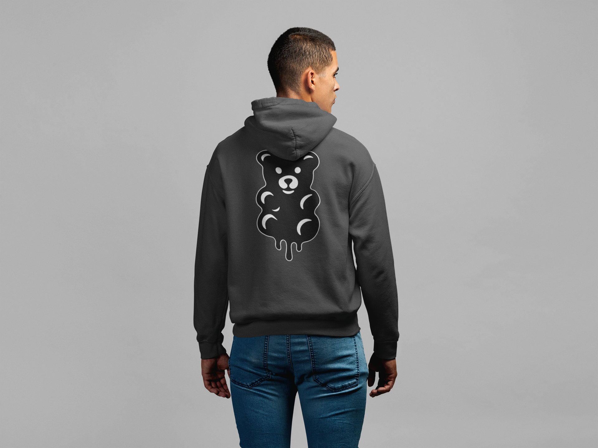 Person wearing a gray hoodie with a bear graphic on the back against a gray background