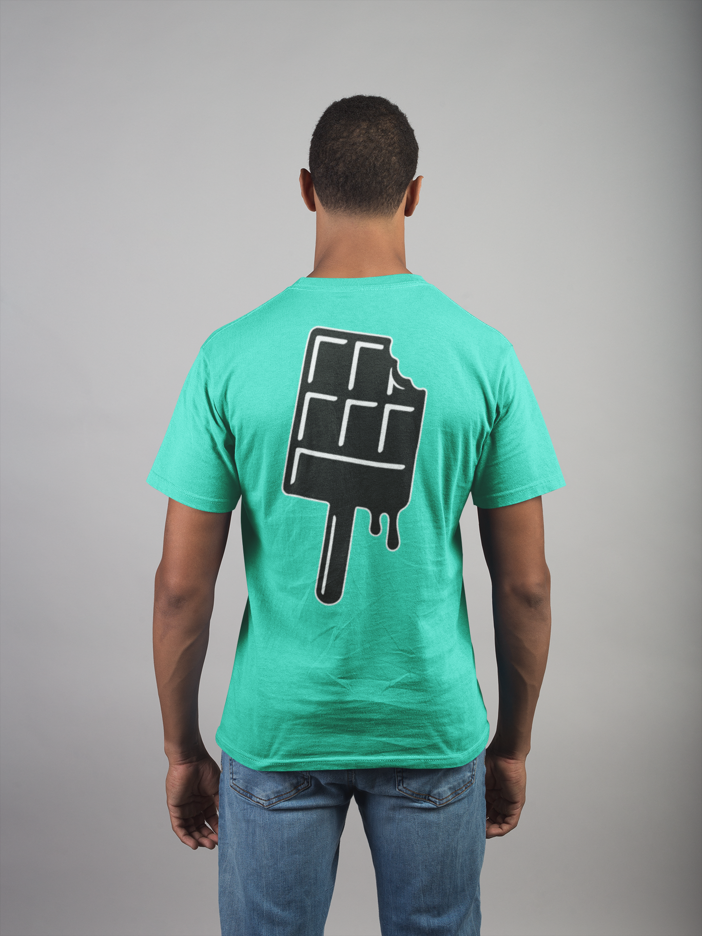 Man wearing a teal t-shirt with a black and white chocolate bar on a stick, graphic on the back against a gray background