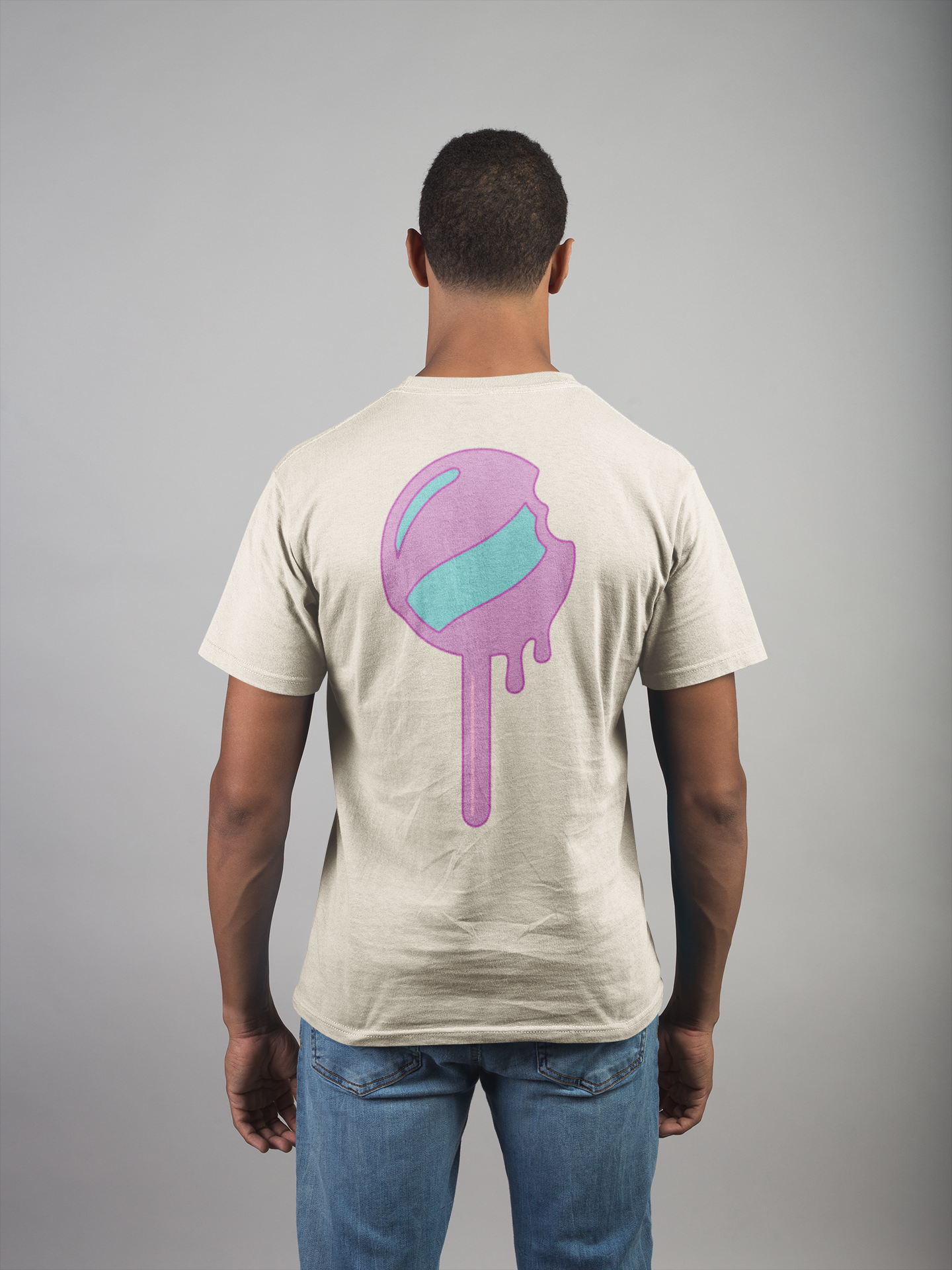 Man wearing a beige t-shirt with a colorful graphic on the back against a gray background