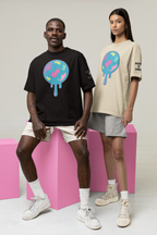 Two people wearing t-shirts with colorful  jaw breaker graphic designs on a plain background