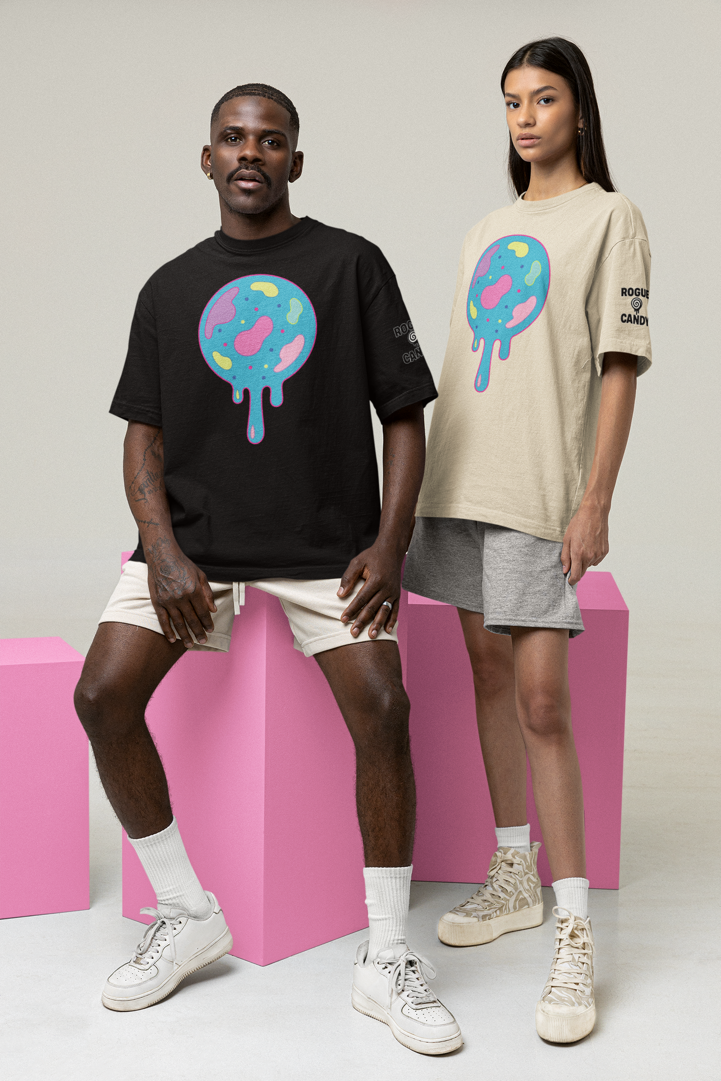 Two people wearing t-shirts with colorful  jaw breaker graphic designs on a plain background