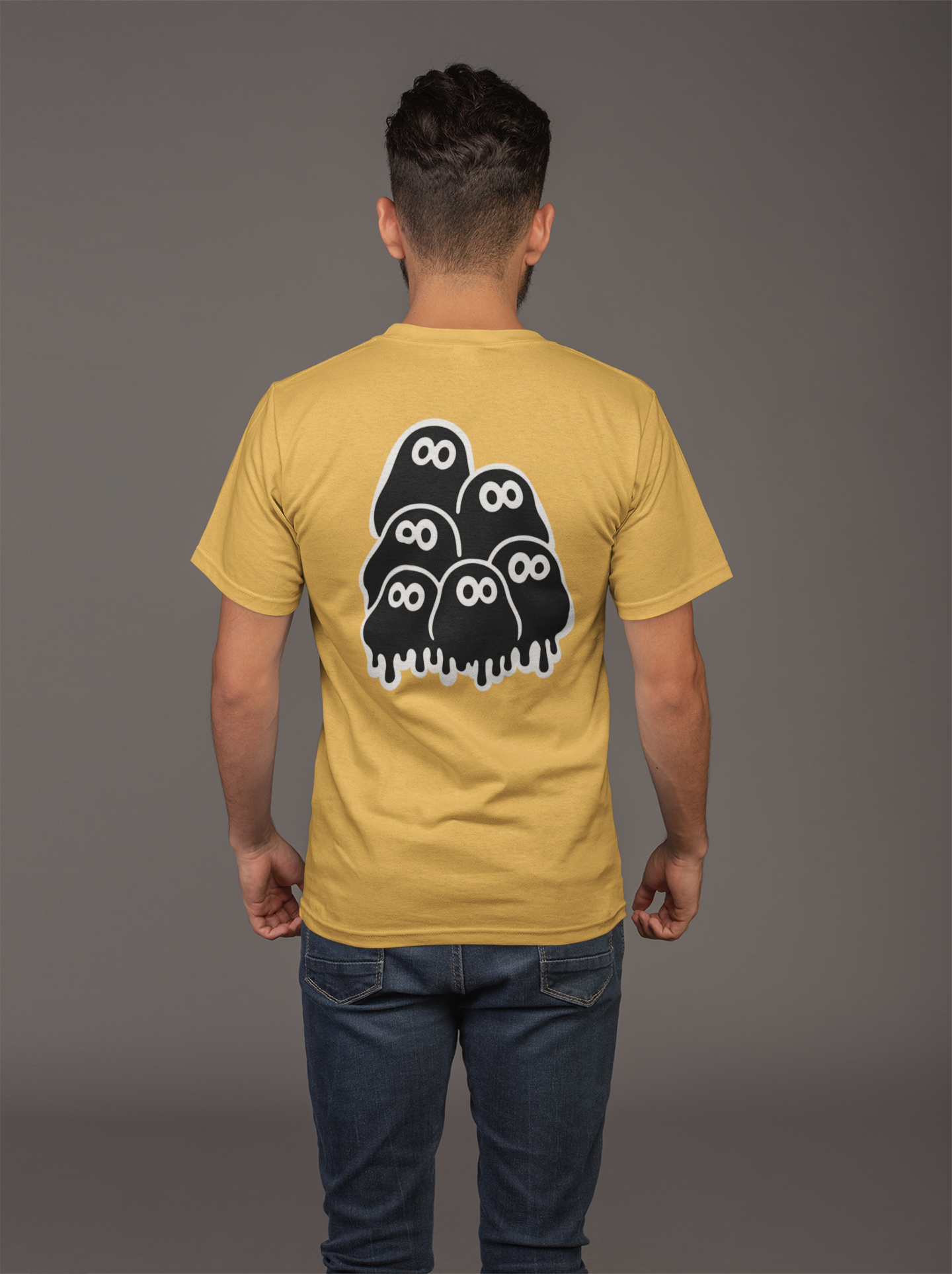 Man wearing a yellow mustard t-shirt with a black and white graphic geek clusters on the back against a gray background