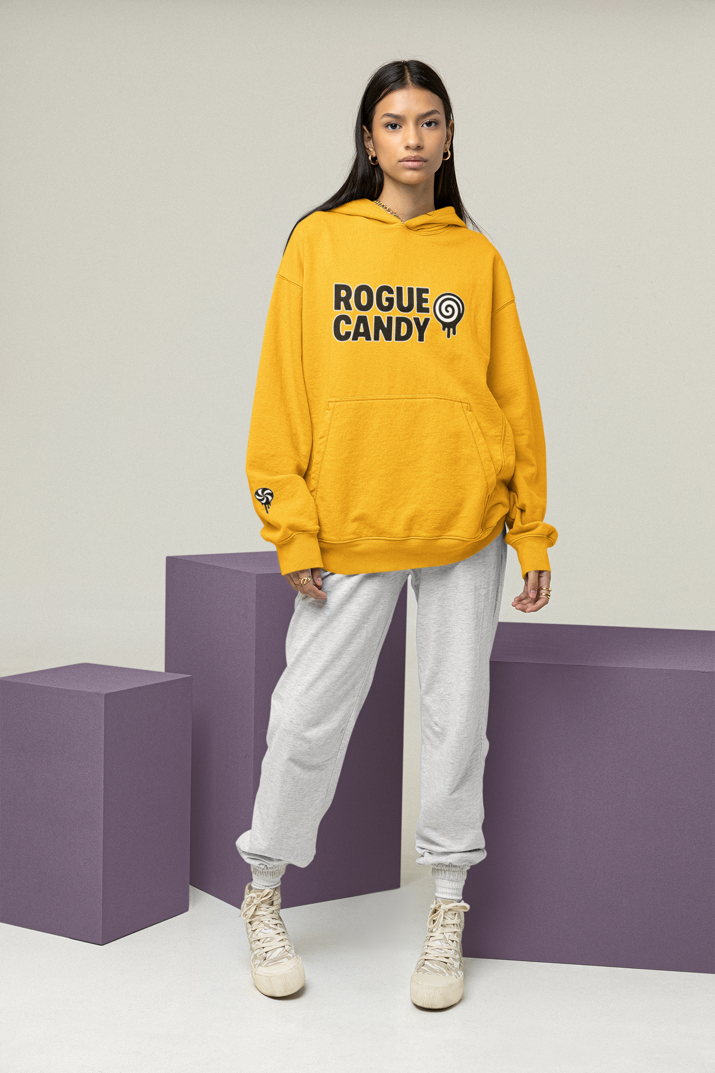Person wearing a yellow hoodie with 'Rogue Candy' logo on a plain background