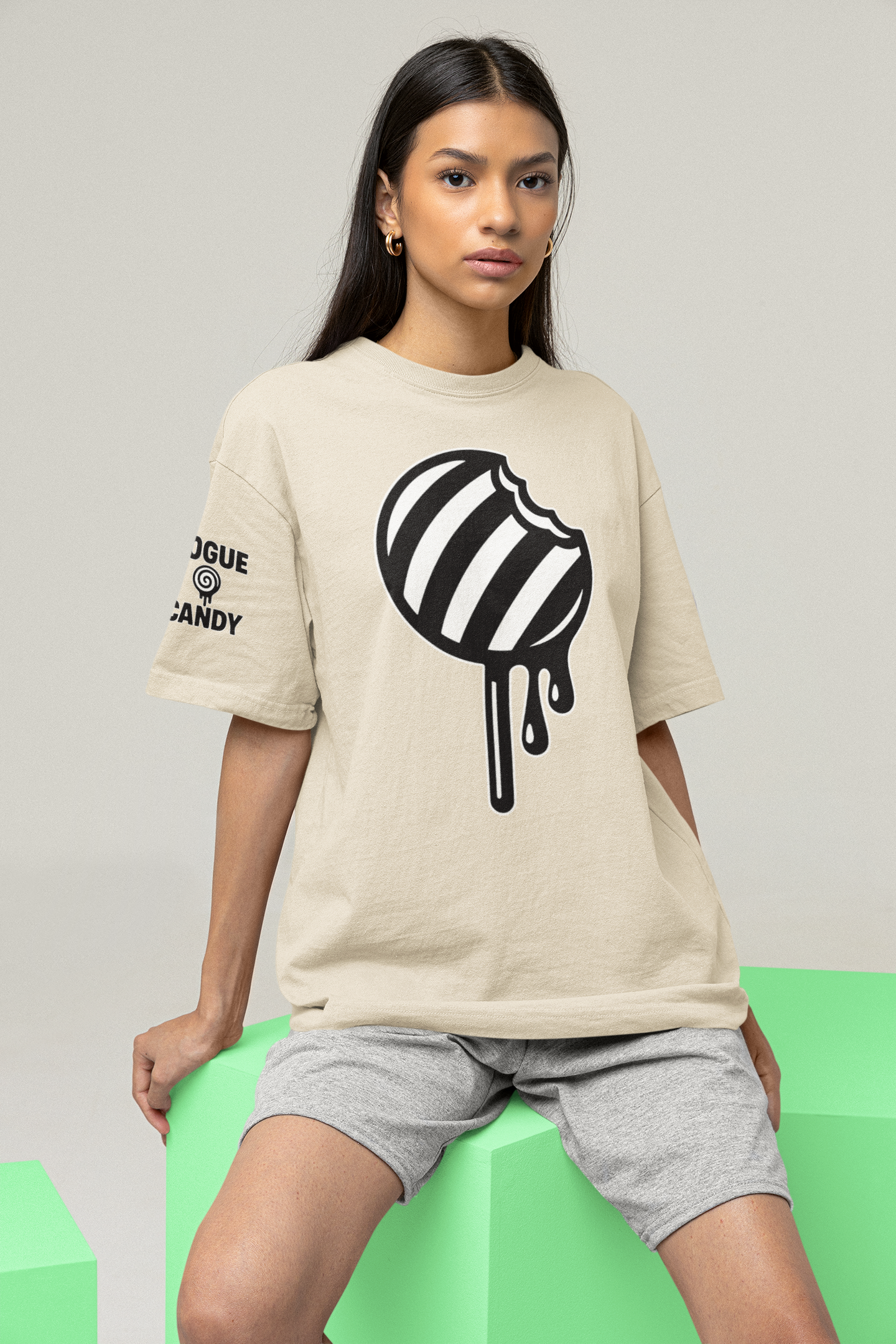 Woman wearing a beige t-shirt with a black and white graphic design on a gray background