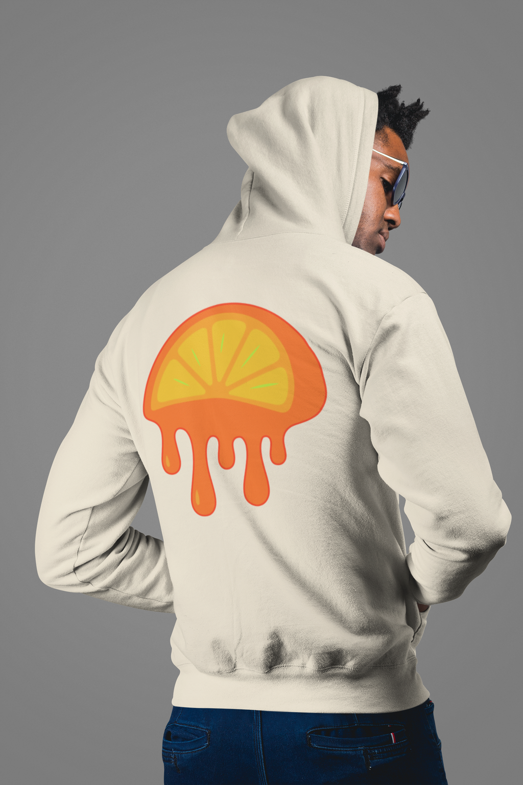 Person wearing a off white hoodie with a colorful design on the back against a gray background